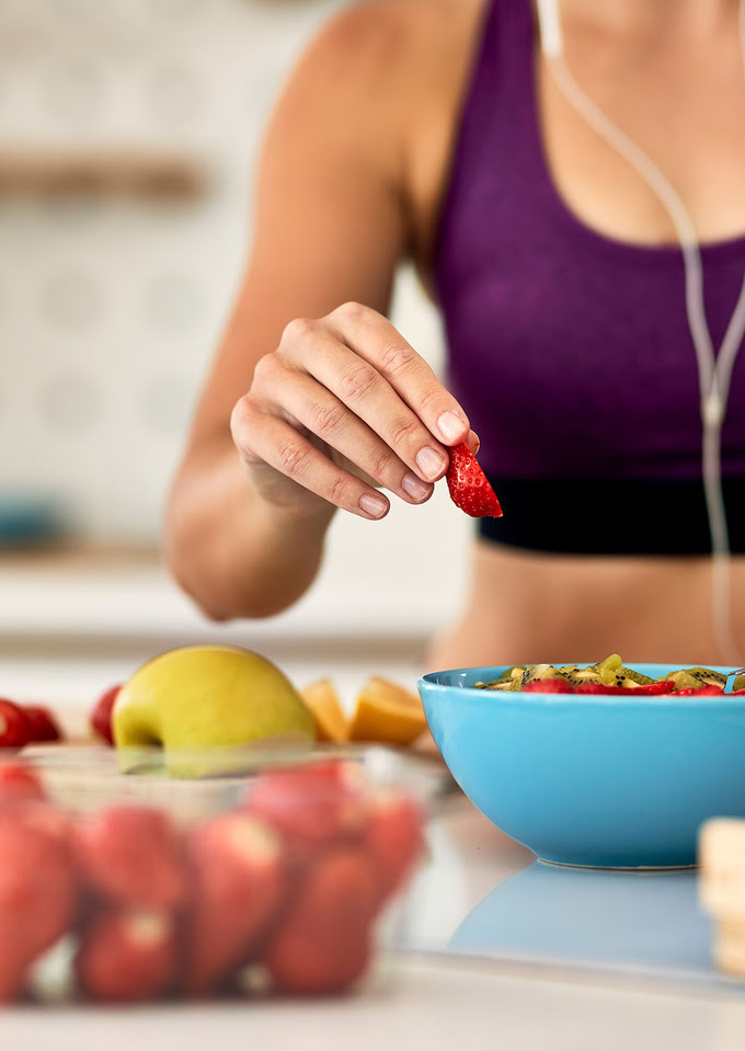`Femme athlétique mangeant des fruits et du muesli, illustration d’une alimentation équilibrée – Fabien Lageyre, diététicien-nutritionniste à Dax et Saubrigues