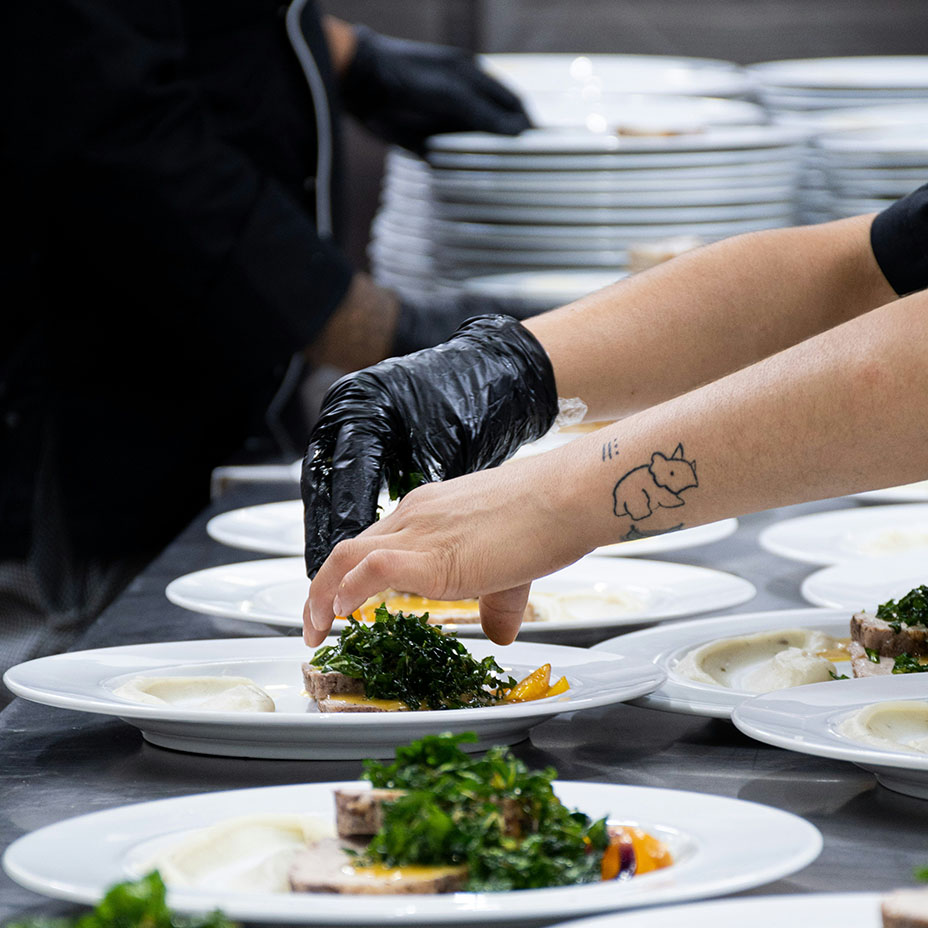 Mains d’un cuisinier préparant des plats en ajoutant des herbes sur plusieurs assiettes à la suite – Fabien Lageyre, diététicien-nutritionniste à Dax et Saubrigues